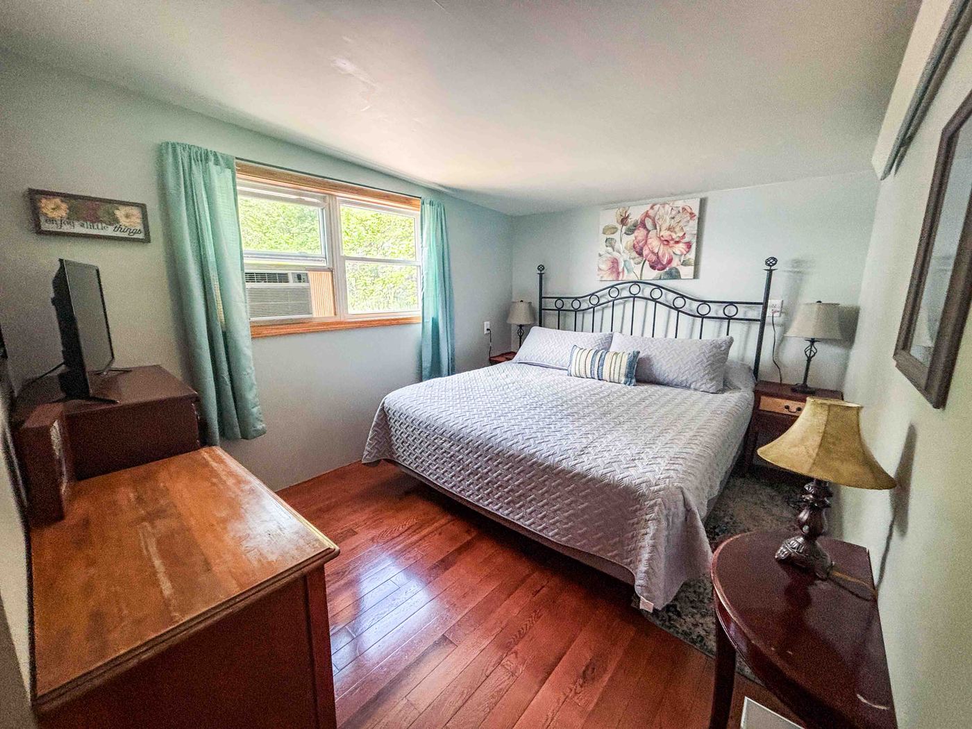 A bright Sunset Haven bedroom with a queen bed and blue accents